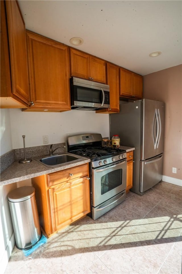 kitchen featuring stainless steel appliances, sink, and light tile patterned floors