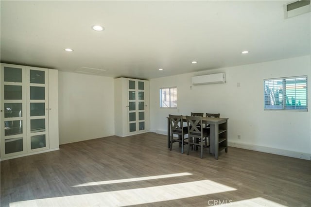 unfurnished dining area with an AC wall unit and dark wood-type flooring