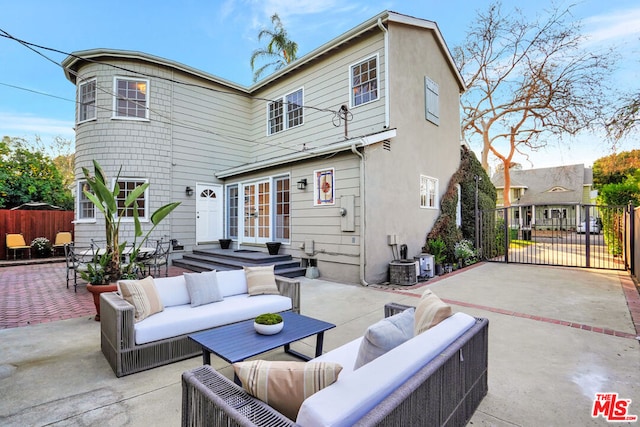 back of property featuring french doors, outdoor lounge area, and a patio area