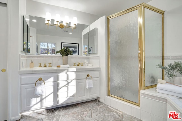 bathroom with a shower with shower door, sink, and decorative backsplash