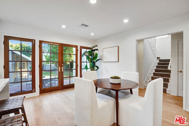 dining space featuring french doors and light hardwood / wood-style flooring