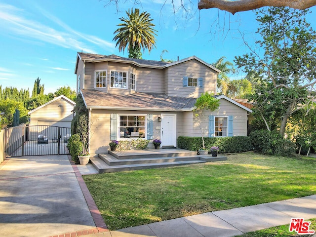 view of front of house featuring a garage, an outbuilding, and a front yard