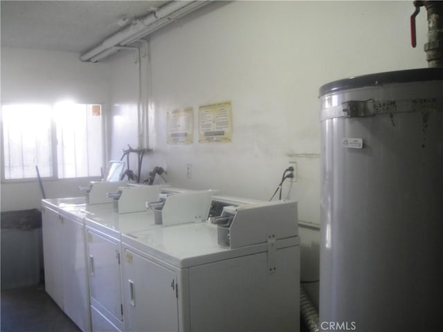 washroom with washing machine and dryer and water heater