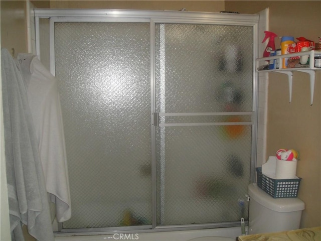 bathroom featuring toilet and a shower stall