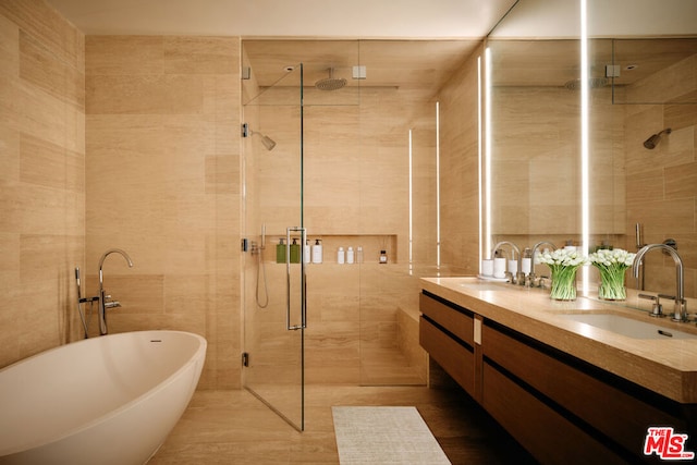 bathroom with vanity, tile walls, and plus walk in shower