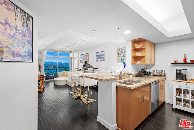 kitchen featuring kitchen peninsula, stainless steel dishwasher, dark hardwood / wood-style flooring, sink, and light stone countertops