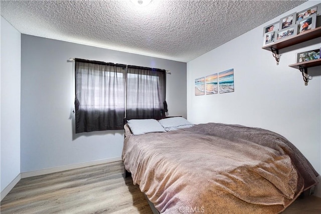 bedroom with wood-type flooring and a textured ceiling