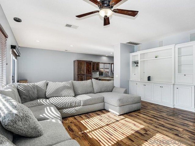 living room with dark wood-type flooring and ceiling fan