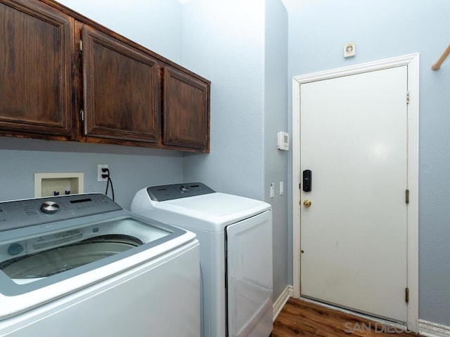 laundry room with dark hardwood / wood-style flooring, cabinets, and separate washer and dryer