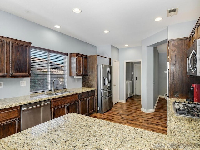 kitchen with light stone countertops, sink, and stainless steel appliances