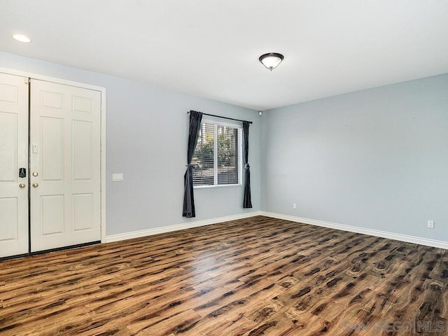 unfurnished room with dark wood-type flooring