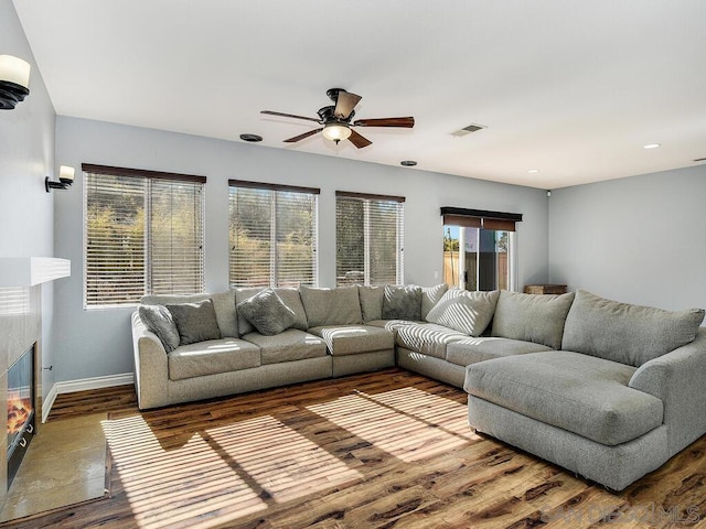 living room with ceiling fan, hardwood / wood-style floors, and a fireplace