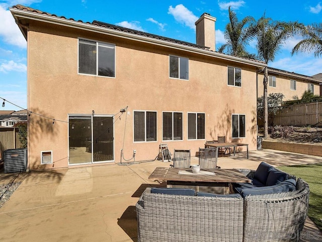 back of house featuring outdoor lounge area and a patio