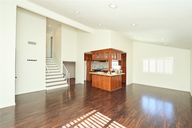 unfurnished living room featuring dark hardwood / wood-style floors and vaulted ceiling