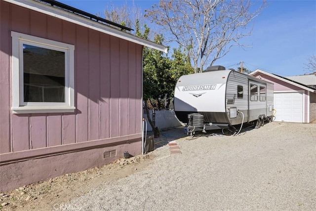 view of side of home featuring a garage and an outdoor structure