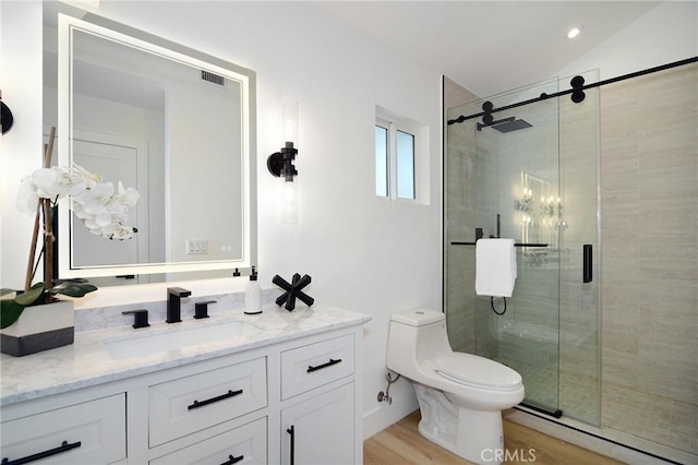 bathroom featuring vanity, hardwood / wood-style flooring, an enclosed shower, and toilet