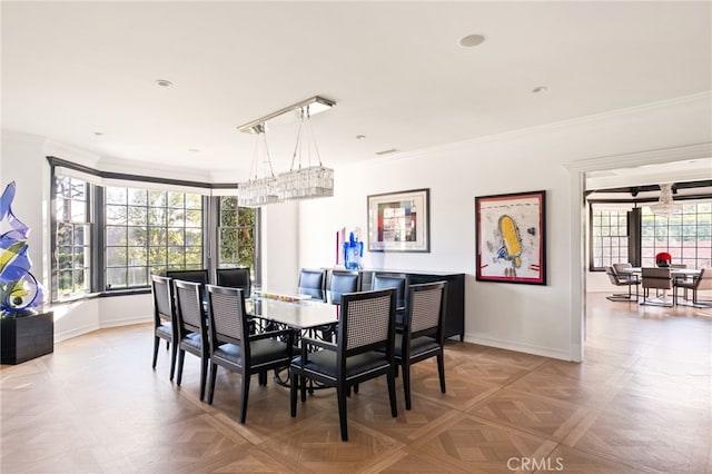 dining area featuring ornamental molding and light parquet flooring