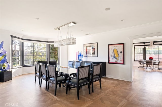 dining room featuring ornamental molding, light parquet flooring, and a healthy amount of sunlight