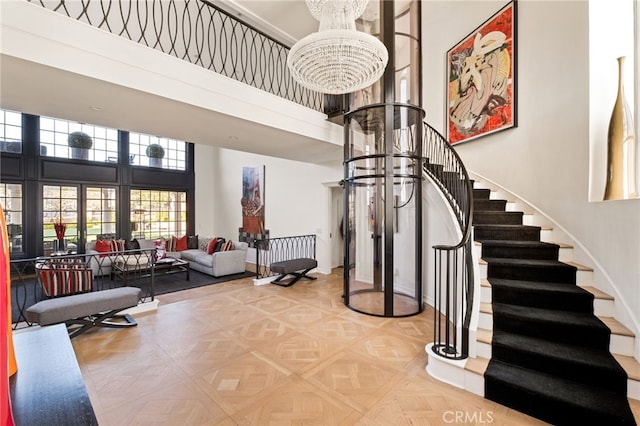 stairs with an inviting chandelier, parquet flooring, and a high ceiling