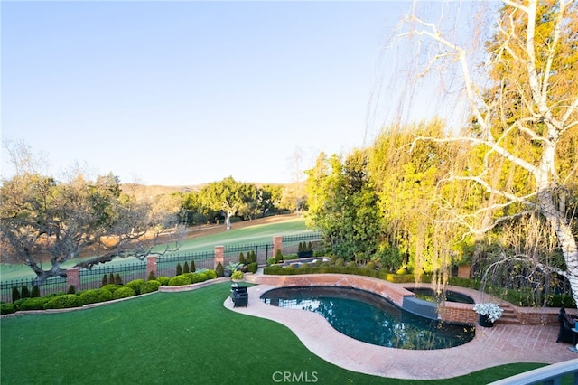 view of swimming pool featuring a yard and an in ground hot tub