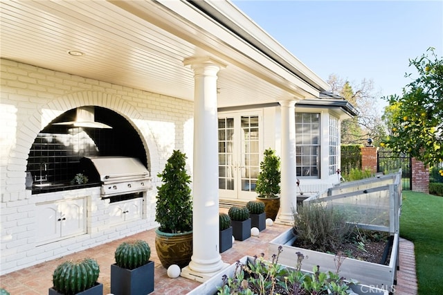 view of patio with exterior kitchen, area for grilling, sink, and french doors