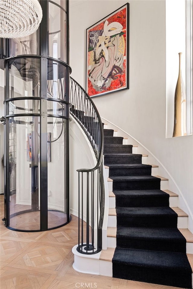 stairway featuring parquet floors