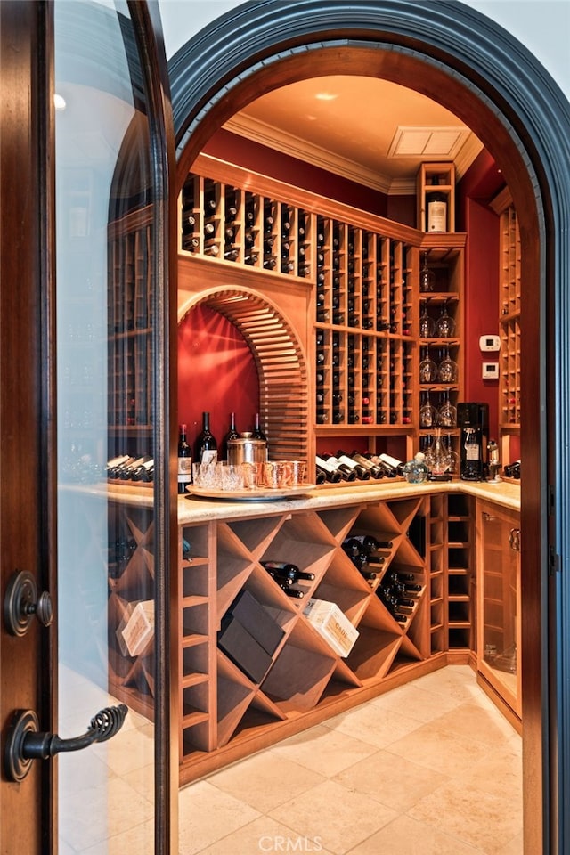 wine cellar featuring tile patterned flooring and crown molding