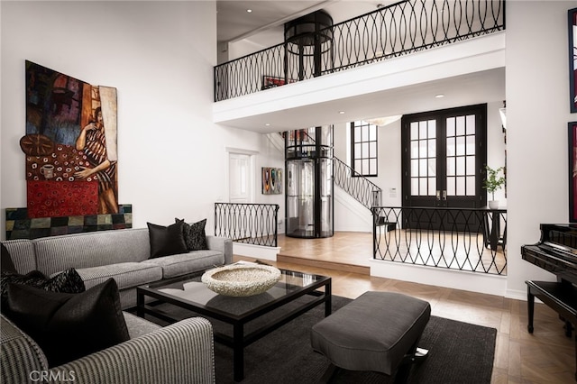 living room with stairs, baseboards, and a towering ceiling