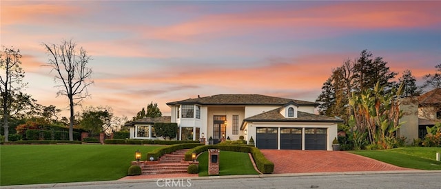 view of front of property with a yard, a garage, and driveway