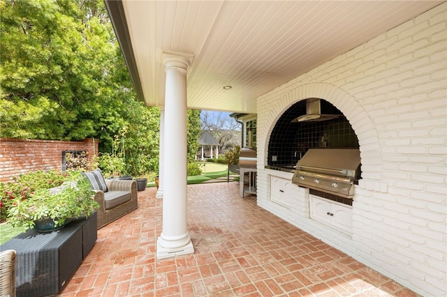 view of patio featuring an outdoor living space, a grill, and an outdoor kitchen