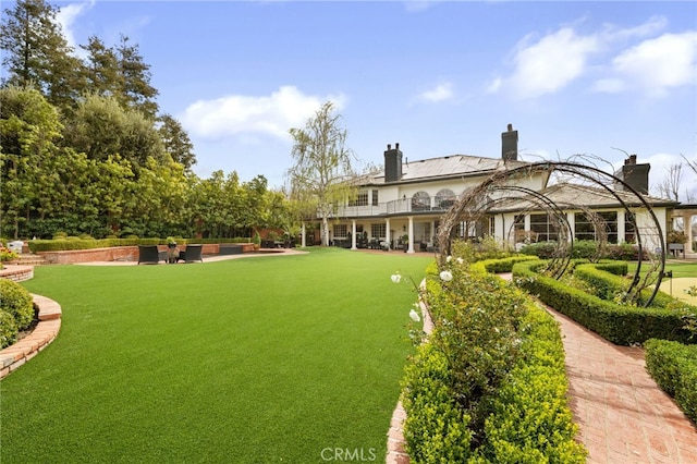 view of yard with a patio and a balcony