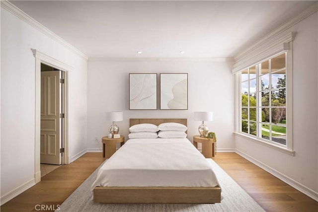 bedroom with baseboards, wood finished floors, and crown molding