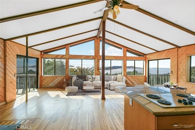 sunroom / solarium with a mountain view, ceiling fan, and lofted ceiling with beams