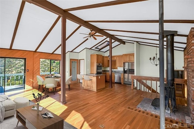 unfurnished living room with ceiling fan, light hardwood / wood-style floors, high vaulted ceiling, and beamed ceiling