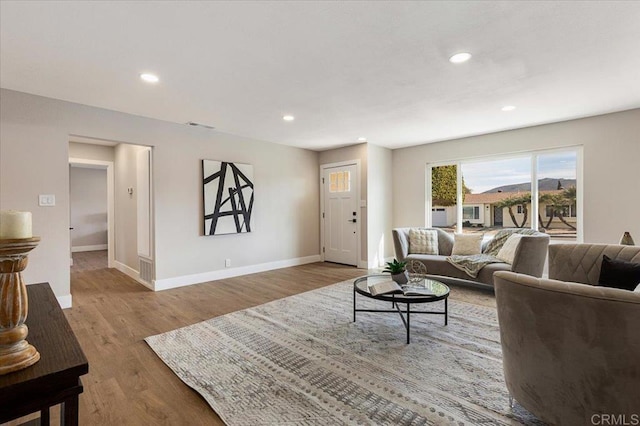 living area featuring visible vents, baseboards, wood finished floors, and recessed lighting