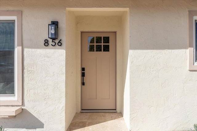 entrance to property featuring stucco siding