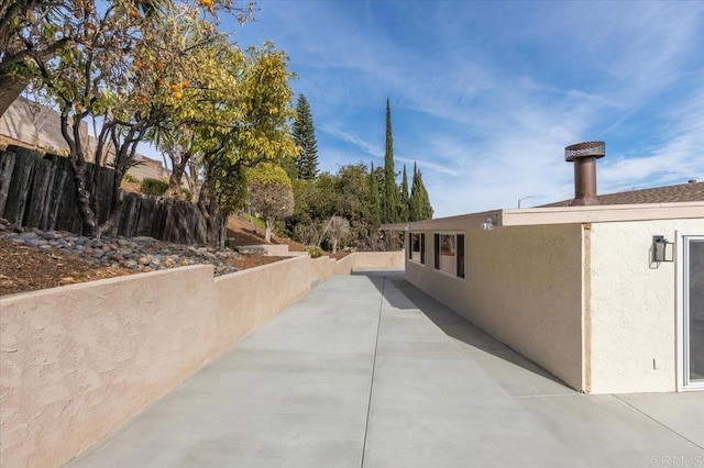 view of home's exterior with a patio area, fence, and stucco siding