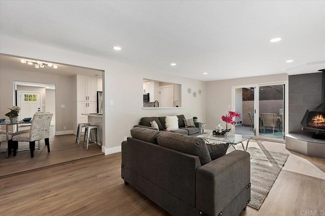 living area with recessed lighting, baseboards, and wood finished floors