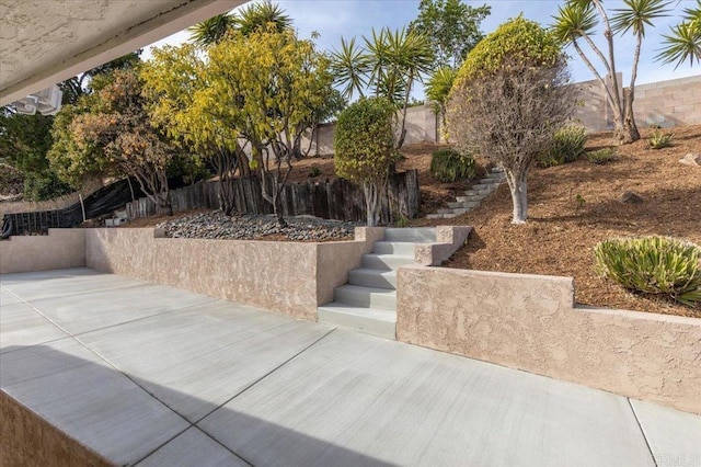 exterior space featuring fence, stairway, and a patio