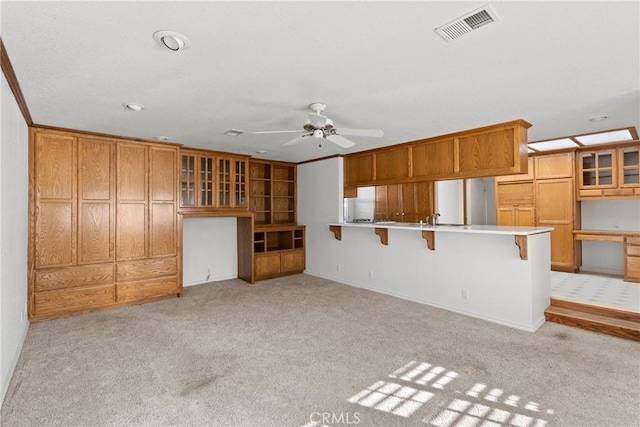 unfurnished living room featuring light carpet, sink, ceiling fan, and crown molding