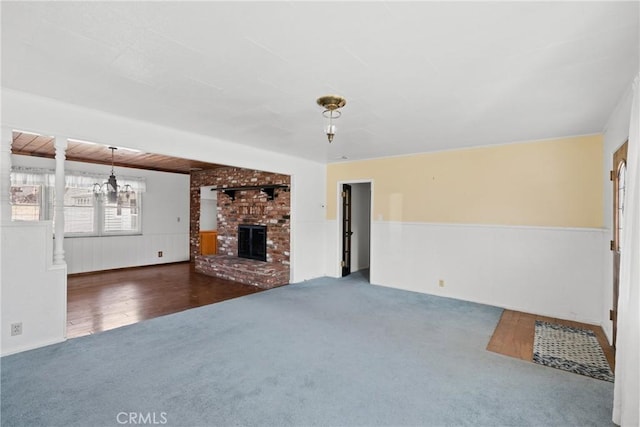 unfurnished living room with dark colored carpet and a fireplace