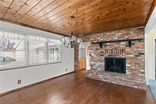 unfurnished living room featuring wood-type flooring, a fireplace, ornamental molding, a chandelier, and wooden ceiling