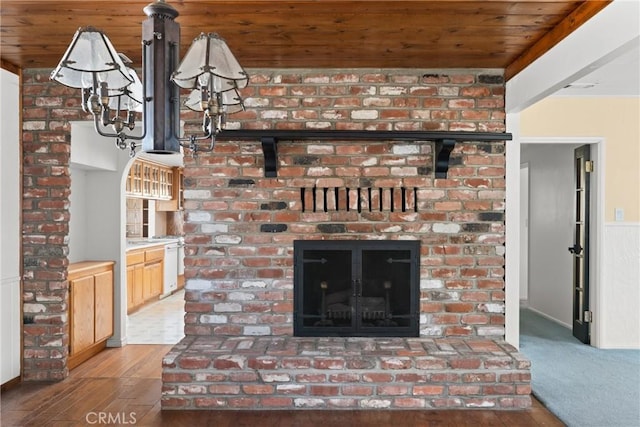 interior details featuring hardwood / wood-style flooring, wooden ceiling, and a brick fireplace