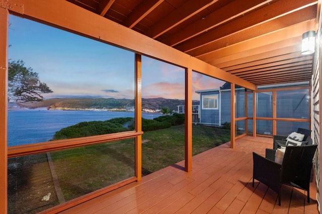 unfurnished sunroom featuring a water and mountain view