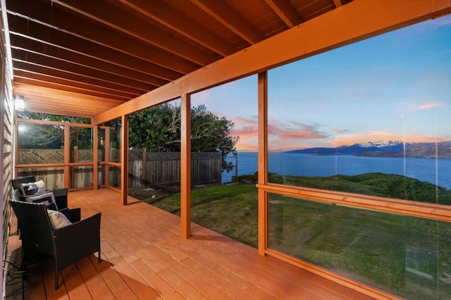 unfurnished sunroom with a water view and beam ceiling