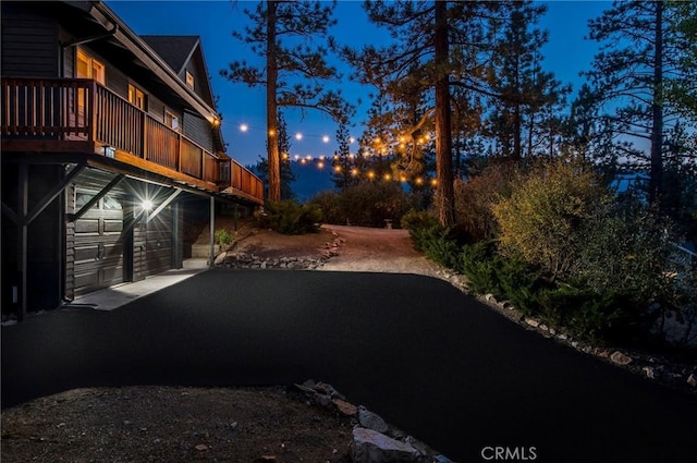 yard at night featuring a garage