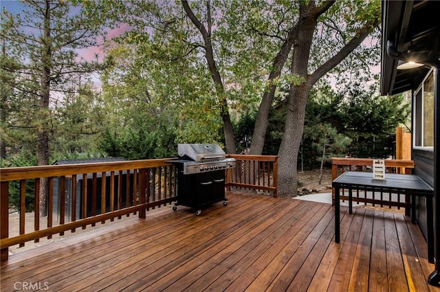 deck at dusk featuring area for grilling