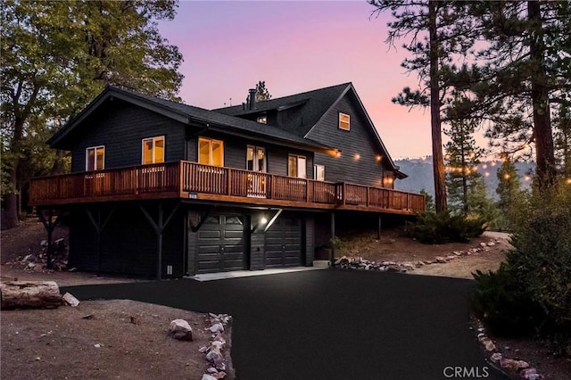 exterior space with a garage and a wooden deck