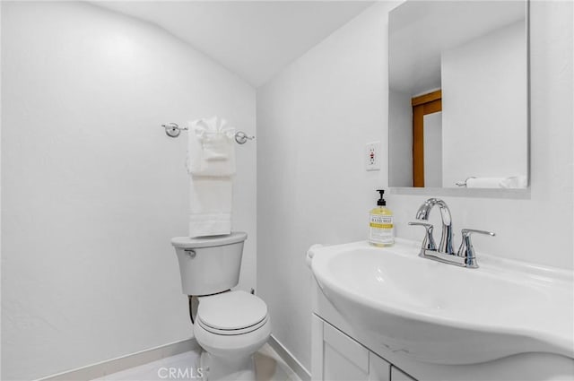 bathroom with vanity, toilet, and lofted ceiling