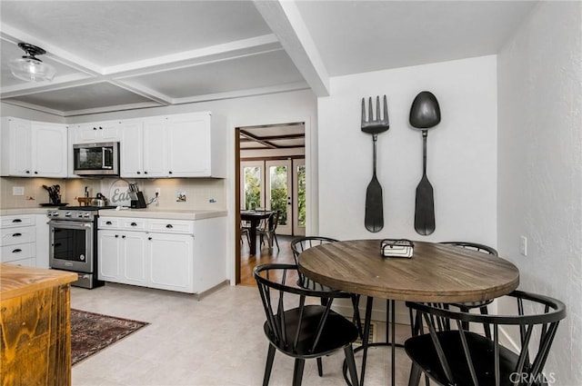 kitchen with appliances with stainless steel finishes, white cabinets, coffered ceiling, decorative backsplash, and beamed ceiling